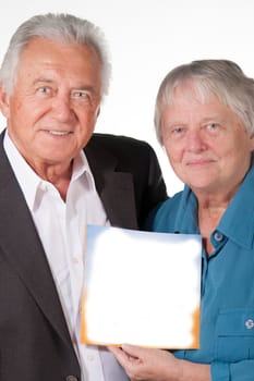 Senior couple holding up a book