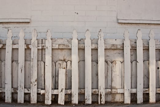 Old picket fence aginst white wall