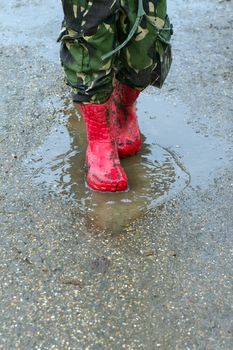 Two brothers splashing in puddles