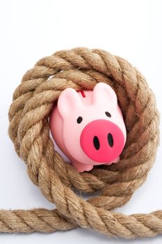 Piggy bank tied by rope on white background