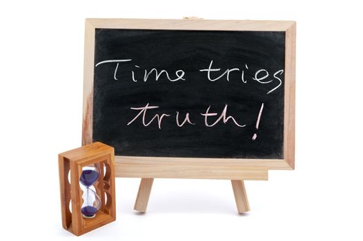 "Time tries truth" sayiings written on chalkboard with an hourglass beside it