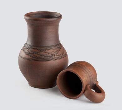 Isolated clay jug and mug on the white background
