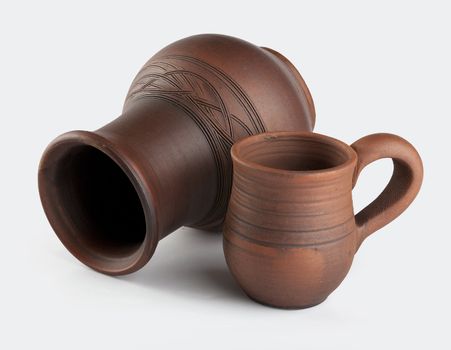 Isolated clay jug and mug on the white background