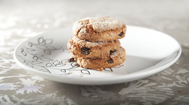 Three ginger cookies with raisins on the white plate