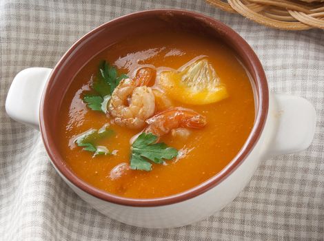 Tomato soup with shrimps, lemon and parsley in the bowl