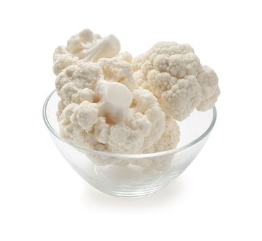 Some branches of cauliflower in the glass bown on the white