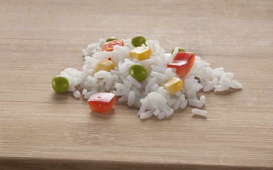 Vegetable mix with rice, peas, corn and paprika on the wooden board