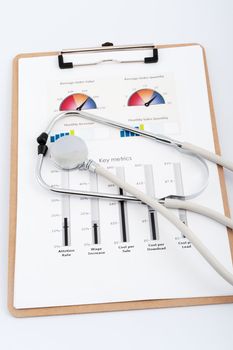 Business graph printed on the white paper with a stethoscope on it