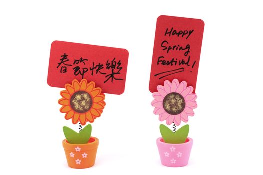 Paper card written "Happy Spring Festival"  bilingual words in both English and Chinese attached on  sun flower pot clip