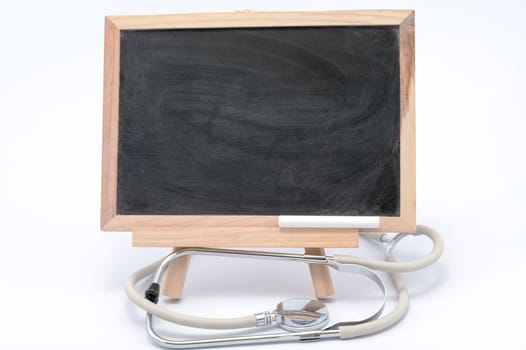 Stethoscope and blackboard on white background