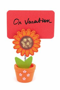 On vacation words written on red paper of sun flower pot clip