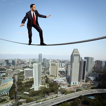 Business man balancing high over a cityscape