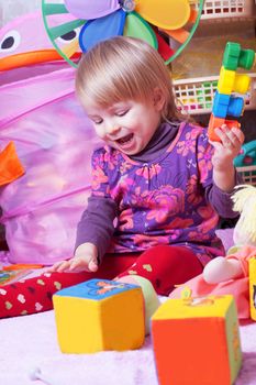Happy baby girl playing in nursery