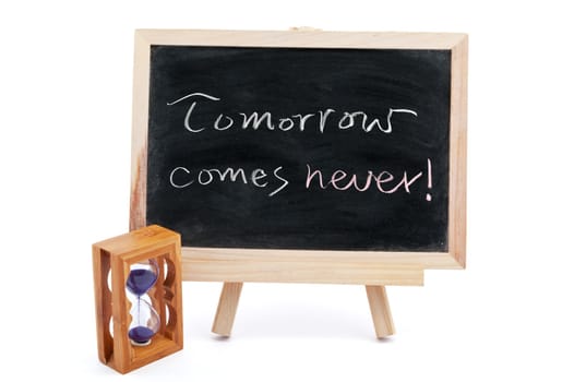 "Tomorrow comes never" saying written on blackboard