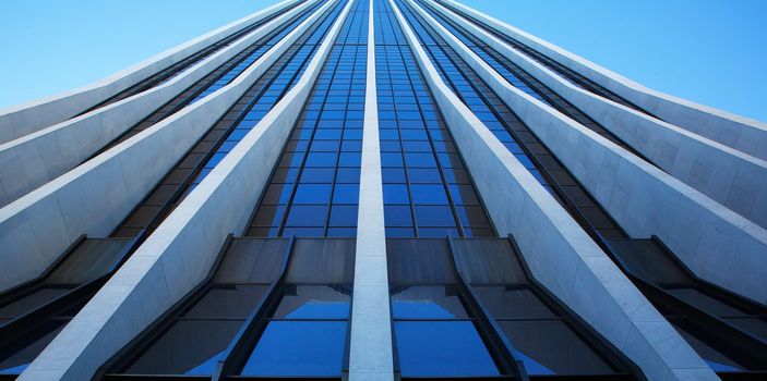 Close up vertical view of modern office building on a clear day that looks like a speed ramp to the sky