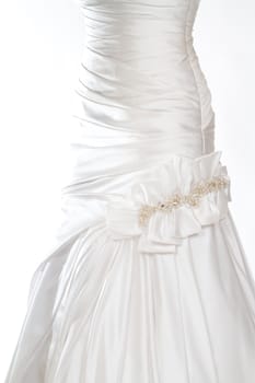 A beautiful white wedding dress is isolatede against a simple background in the studio.