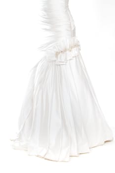 A beautiful white wedding dress is isolatede against a simple background in the studio.