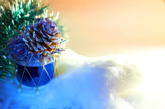 Glass Christmas toy  in the form of pine cone on the drum on the artificial Christmas tree branches