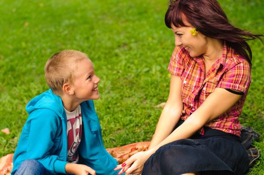 Mother and son play outside on field in the park