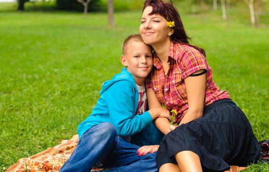 Mother and son play outside on field in the park