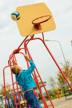 Young boy playing basketball at outdoors playground