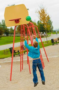 Young boy playing basketball at outdoors playground