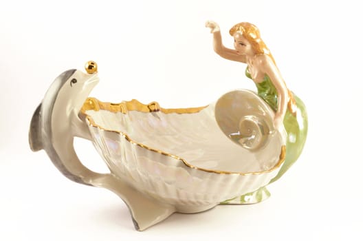 Ceramic figurine in the form of a dolphin and a mermaid on a white background