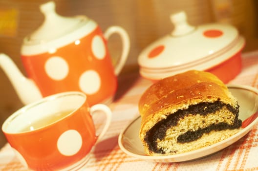 Homemade pie with poppy seeds on a background of tea set