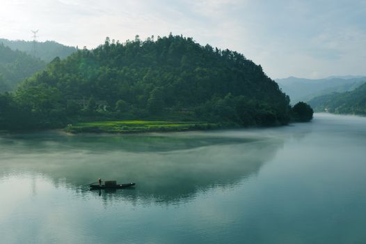 Morning fog rolls across the chilly river water, photo taken in hunan province of China