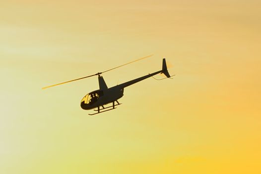Helicopter flying over the sky at sunset