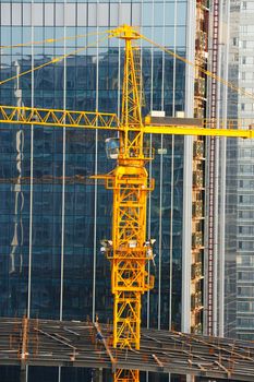 Close up of a crane before a modern building