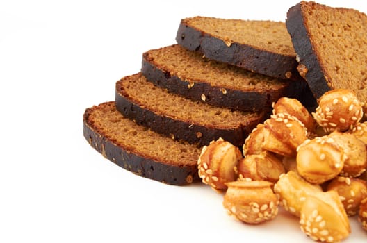 Fresh rye sliced ​​bread sprinkled with coriander and puff balls on a white background