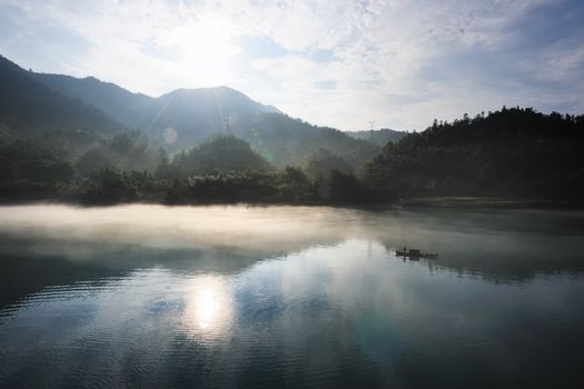 Morning fog rolls across the chilly river water, photo taken in hunan province of China