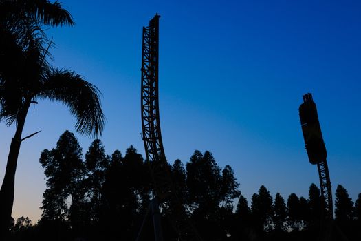 Silhouette of recreational facilities in the amusement park under blue sky