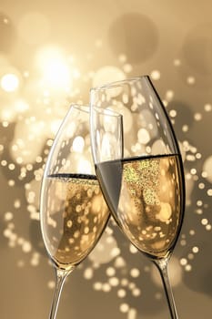 An image of two Champagne glasses on light bokeh background