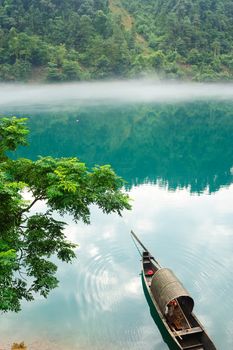 Fishing boat on the foggy river, photo taken in hunan province of China