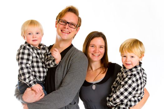 An attractive couple and their two sons against an isolated white background in the studio for a family portrait.
