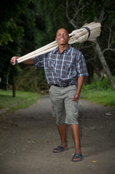 Stock photograph of a smiling black South African entrepreneur small business broom salesman in Hilton, Pietermaritzburg, Kwazulu-Natal