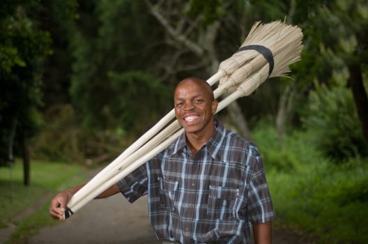 Stock photograph of a smiling black South African entrepreneur small business broom salesman in Hilton, Pietermaritzburg, Kwazulu-Natal