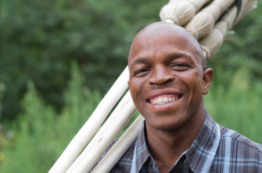 Stock photograph of a smiling black South African entrepreneur small business broom salesman in Hilton, Pietermaritzburg, Kwazulu-Natal