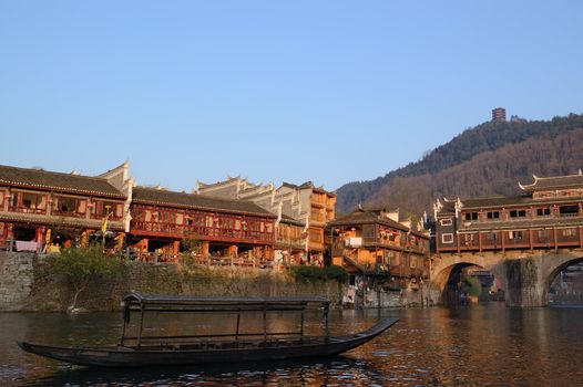 China river landscape with boat and ancient building in Fenghuang county, Hunan province, China