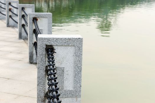 Handrail by the lake made of stone and iron trail 