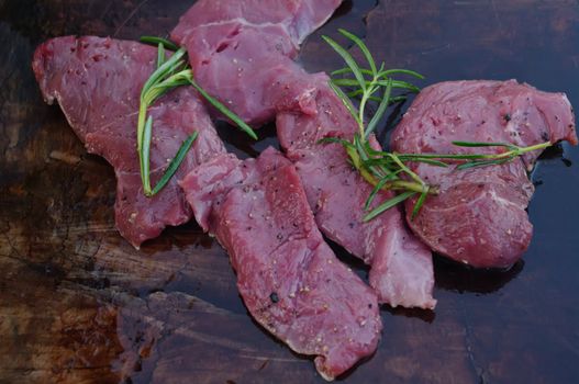 deer meat on bbq flagstone with rosemary