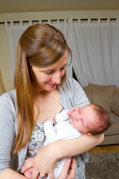 A mother holds her newborn baby boy in her arms.