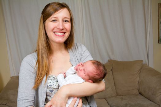 A mother holds her newborn baby boy in her arms.