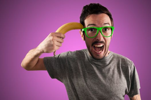 man attempting suicide with a banana on pink background