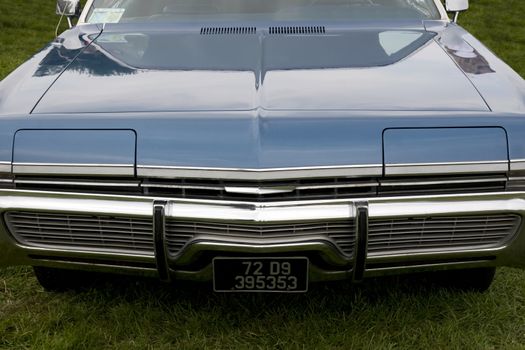 the hood of a classic American blue car with an altered number plate