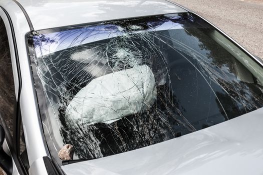 Road accident crash damaged car or wreck broken vehicle with used airbag