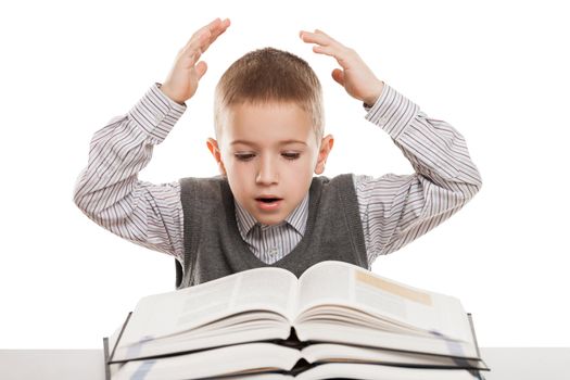 Amazed or surprised child boy reading education books at desk