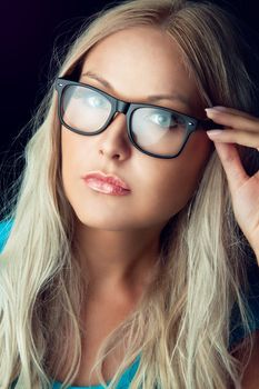 Blonde girl wearing glasses and looking aside 